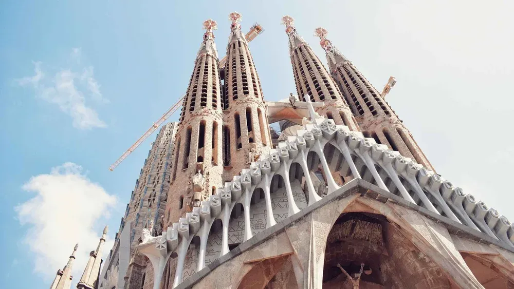 Guide pointing at the Passion facade sculptures during a skip-the-line la sagrada familia tour